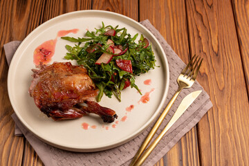 Baked duck leg with arugula, radish and red orange salad, open space, flat lay