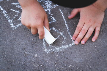 Children draw with chalk on the road. Children's creativity on the street.