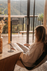 woman reading a book in scandinavian home in bali