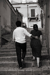 Obraz na płótnie Canvas A man climbs the stairs with a woman hugging her waist