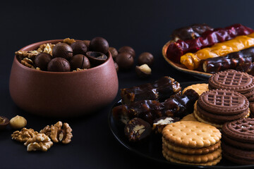 Georgian churchkhela in a plate on a dark table with nuts and other sweets. Close-up