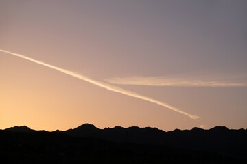 Beautiful sunrise light on sky over  horizon with mountains. Jet trace in the sky. View around Aqaba, Jordan