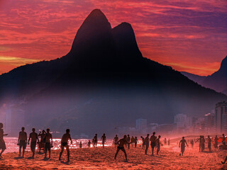 Playing soccer at Leblon Beach at sunset. Leblon is a neighborhood of Rio de Janeiro with most expensive price per residential square meter in Latin America. Rio de Janeiro, Brazil, Jan 2019