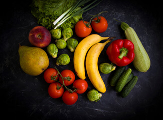 Different vegetables and fruits on a dark background