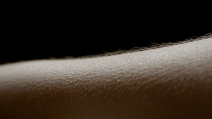 Macro shot of hairy skin of young African American woman on black background | Skin texture shot for skin moisturizing concept