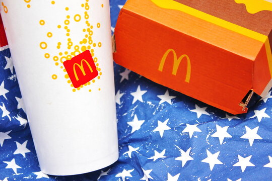 Washington, USA - July 07 2022 : McDonald's Soft Drink Glass and a box of McDonald's burgers Placed on American flag star pattern cloth, McDonald's is a popular food for Americans.
