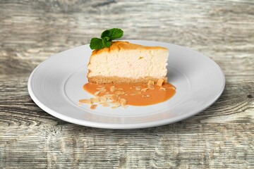 Tasty sweet cake decorated with fresh green mint leaf on white ceramic plate.Traditional dessert.