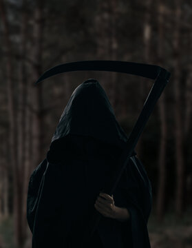 Death holding a scythe, a gloomy forest in the background.