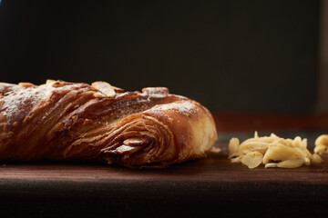 French artisan bread, almond tie name bread placed on a wood and almonds to the side