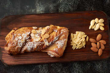 French artisan bread, almond tie name bread placed on a wood and almonds to the side