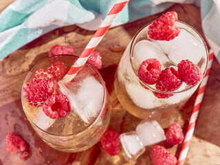 2 Cup Ice tea with raspberries and ice cubes.