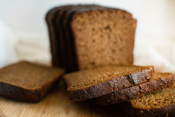 Black bread lies on a wooden cutting board