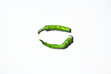 Flat lay composition of green chili peppers, isolated on white background. Copy space. Top view. Horizontal studio shot