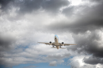 Airplane flying through storm clouds - obrazy, fototapety, plakaty