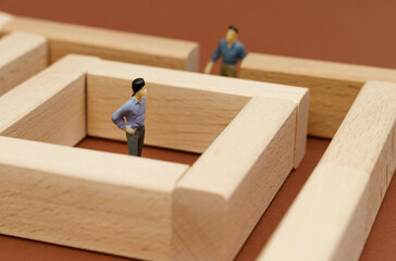Wooden blocks on a brown surface. In blocks, a person is isolated from other people.