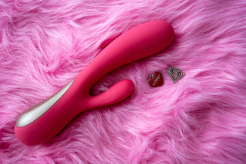 pink vibrator sex toy with hearts on pink background - obrazy, fototapety, plakaty