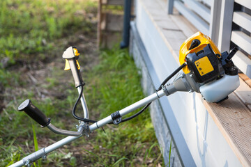 Petrol trimmer on the veranda of a country house