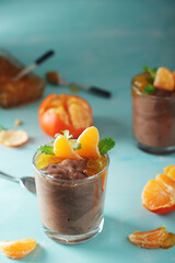 Chocolate mousse dessert with tangerines in glasses