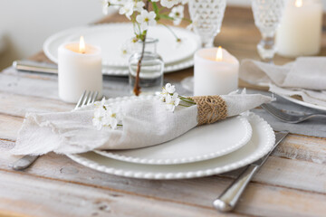 Obraz na płótnie Canvas Rustic zero waste wedding decor with natural elements. Wooden table, candles, linen napkins, branches with green leaves. Eco-friendly decoration for the special dinner. Romantic and cozy place
