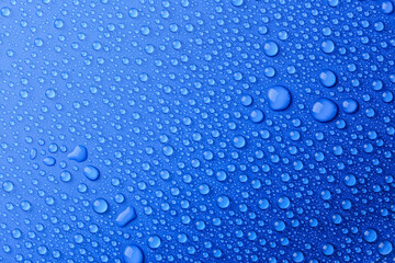 Naklejka na ściany i meble Water drops on blue background, top view