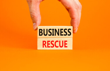 Business rescue symbol. Concept words Business rescue on wooden blocks on a beautiful orange table orange background. Businessman hand. Business rescue and support concept. Copy space.