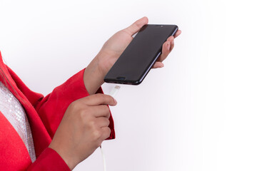 hands of hispanic girl holding cell phone connecting charger cable, isolated on white background