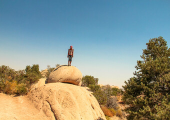 Filipina woman on top of sandstone boulder, looking like a rocket ready to take off, Devil's...