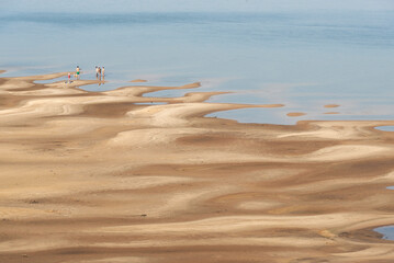 Summer minimal landscape, distant view of people enjoying a river beach in El Palmar National Park, Entre Rios, Argentina. Simple aesthetic image for the concept of vacations and enjoyment of nature.