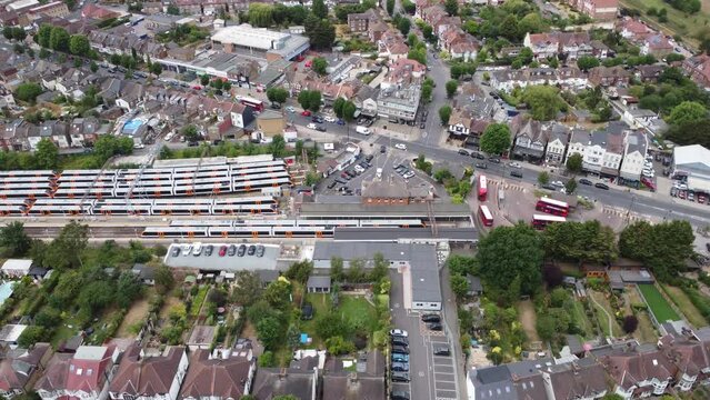 Panning across trains waiting on platforms at Chingford Station. Aerial view. London