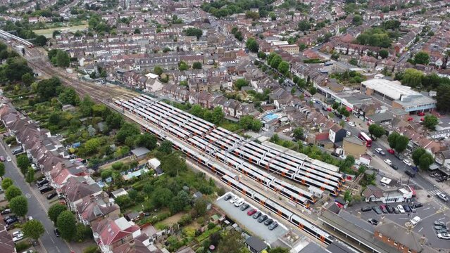 Panning across trains waiting on platforms at Chingford Station. Aerial view. London