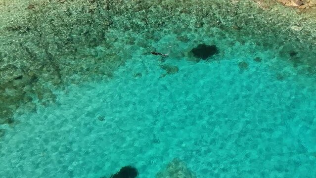 Aerial topdown view of the colorful seabed in Milia beach in Alonnisos island, Greece, Europe.