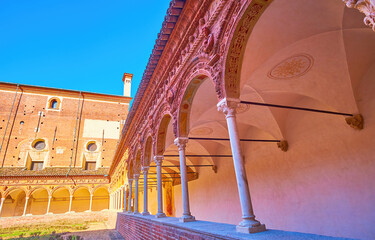 Walk along the covered gallery of small cloister of Certosa di Pavia monastery, Italy