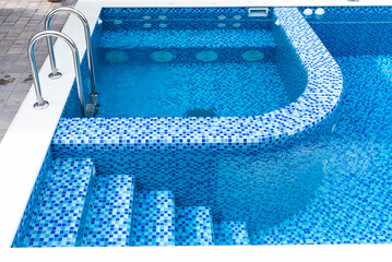 Swimming pool with blue tiles. Steps and separate jacuzzi area. Relax in the backyard of a country...