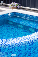 Fototapeta na wymiar Swimming pool with blue tiles. Jacuzzi. Relax in the backyard of a country house