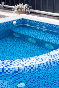 Swimming pool with blue tiles. Jacuzzi. Relax in the backyard of a country house