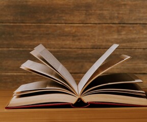 An open old book on a wooden table.