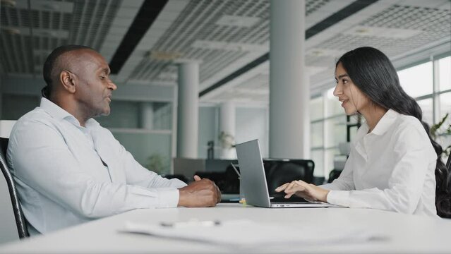 Arabian female banker lawyer financial advisor consult african senior client partner filling personal application form in computer negotiate explain business strategy loan insurance contract benefits