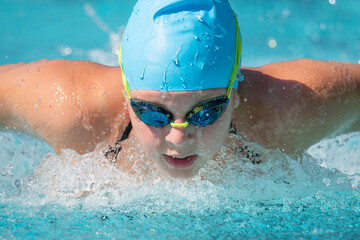 Close up of a teenage girl swimming butterfly