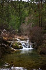 Fototapeta na wymiar mountain stream with small waterfall