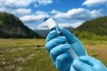 A vial of vaccine for Monkeypox virus, on outdoor background - obrazy, fototapety, plakaty