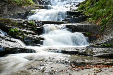 Beautiful waterfall in forest. Waterfall Kozice near Fojnica, Bosnia and Herzegovina. River cascade. Water flows over the rocks in the mountain.