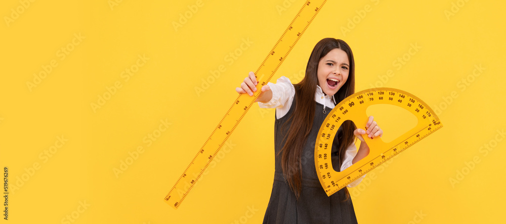 Wall mural emotional child hold math protractor and ruler in school on yellow background. portrait of schoolgir