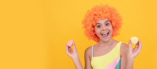 macaroon cookie. happy childhood. birthday party. funny kid in clown wig hold french macaron....