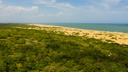 Wild beach and ocean in Kumana national park surrounded by jungle.