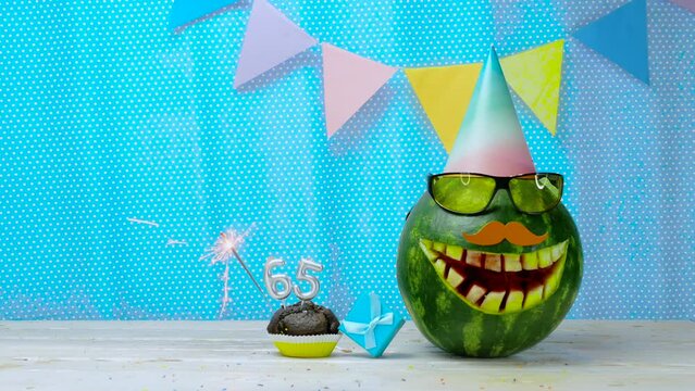 Creative birthday greeting copy space for two year old child. Video postcard happy birthday muffin with candles with number  65. Watermelon character in a comic smile holiday decorations