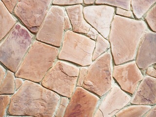 Red sandstone cladding patterned wall. Stone wall tiles. Terracotta sandstone for cladding. Closeup background horizontal image. Not a seamless texture.