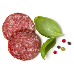 Slices of salami isolated over white background closeup. Sausage and basil leaves top view.. - 519679647