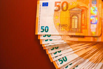 Euro money. Money background.fifty euros banknotes pack on a burgundy background.Spending and income in European countries.Income and expenses in the EU countries.Euro currency.