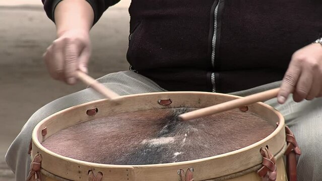 Man Playing a "Bombo Leguero", an Argentine Drum made with Wood and Animal Leather, used in Local Traditional Folklore Music. Close Up.  