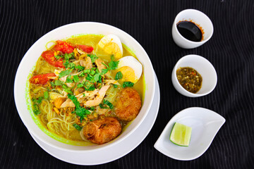INDONESIAN CULINARY CHICKEN SOUP NOODLE WITH SLICE BOILING EGG AND FRIED MASHED POTATOS AS TOPPING